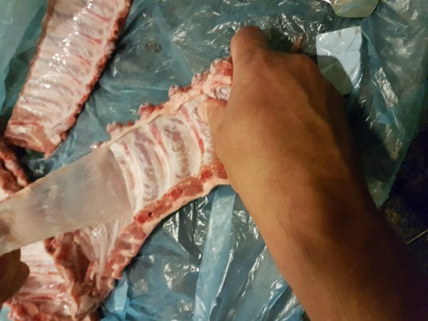 We beginnen met het minder leuke klusje : het ontvliezen van de ribben. Aan de achterkant van de ribben zit nog een longvlies. Deze zal eerst verwijderd moeten worden. Het is even een handigheidje die je moet leren, en soms lukt het simpelweg niet om het vlies goed te pakken te krijgen. Gebruik hiervoor een schroevendraaier of de steel van een lepel. De kunst is om door het vlies heen te prikken en een stuk vlies los te krijgen van de botten. Wanneer je dit voor elkaar hebt kun je het vlies met de handen vastpakken en lostrekken