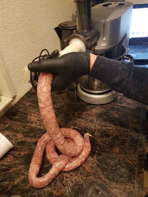 Draai nu rustig het vlees door je molen/stopper. Met ene hand voer je het vlees aan / draai je aan de molen / draai je aan de stopper, met de andere hand geleid je darm. Zorg dat er voldoende vlees in de darm komt alvorens de darm te laten 'vieren'.